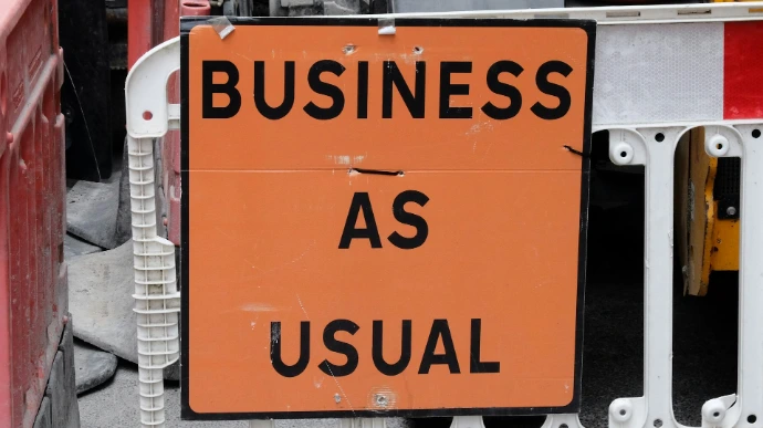 A sign that says business as usual on it